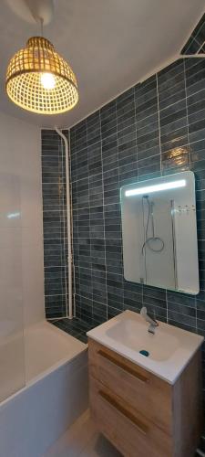 a bathroom with a sink and a mirror and a tub at Dieppe plage à 2min à pied in Dieppe