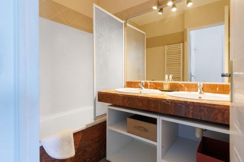 a bathroom with two sinks and a large mirror at Entre Foret et Ocean in Moliets-et-Maa