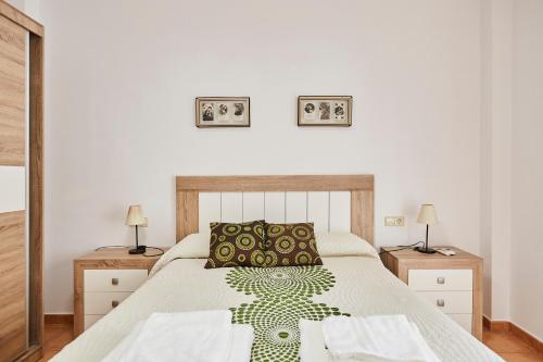 a bedroom with a large bed with two night stands at Casa Emilia in Baeza