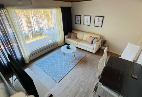 a living room with a couch and a table at The Zen Den Rokua in Utajärvi