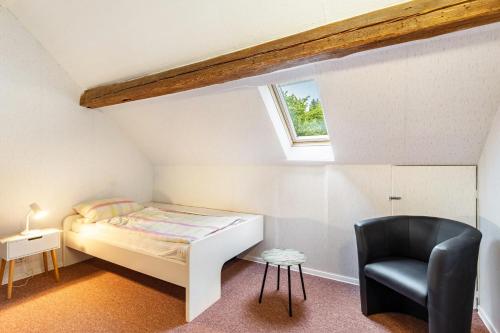 a small bedroom with a bed and a chair at Ferienwohnung Gerke in Warstein