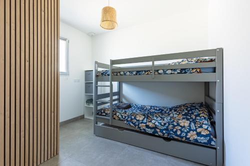 a bedroom with two bunk beds in a room at Villa Bourdaines - Conciergerieland in Vielle-Saint-Girons