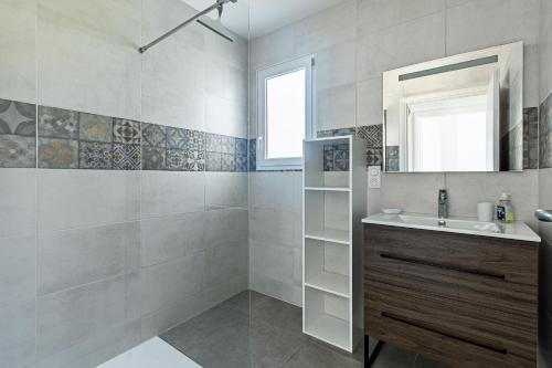 a bathroom with a sink and a mirror at Villa Bourdaines - Conciergerieland in Vielle-Saint-Girons