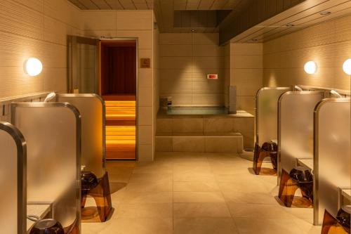 eine Reihe silberner Urinale in einem Badezimmer in der Unterkunft Hotel Global View Iwaki in Iwaki