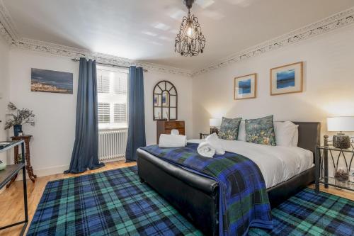 a bedroom with a king sized bed and a chandelier at Driftwood - Pittenweem in Pittenweem