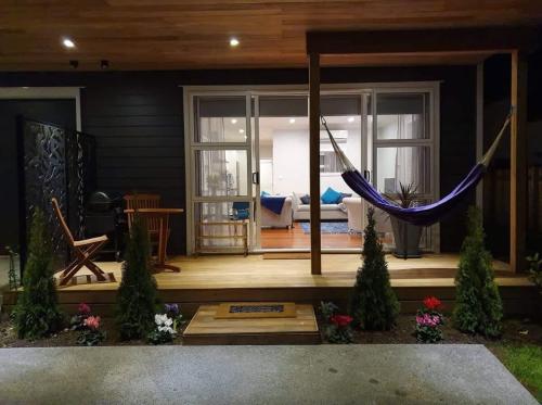 a porch with a hammock and a living room at The Weiti Waterfront in Whangaparaoa
