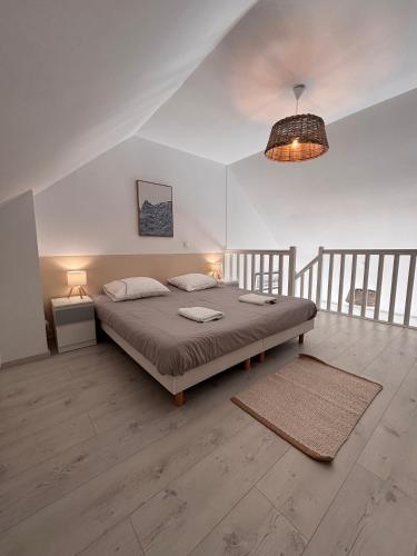 a bedroom with a bed and a pendant light at Ti Mad, Echappée belle à La Baule - mer et piscine in Guérande