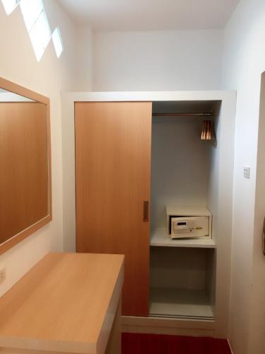 a kitchen with a wooden door and a microwave at Nice Sea Resort in Srithanu