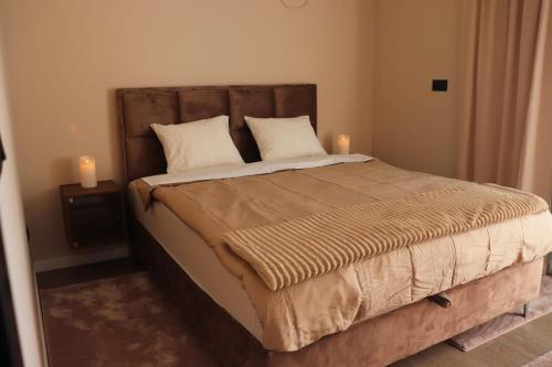 a bedroom with a large bed with two candles on it at Palas rooms in Smederevska Palanka