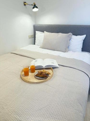 a tray of food on a bed with two glasses of orange juice at Navi Jūra House13 in Palanga