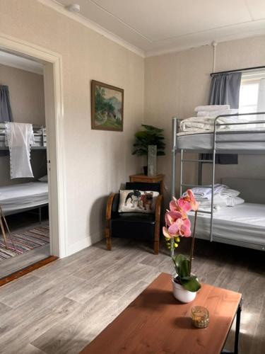 a room with two bunk beds and a table with flowers at Fyrås Gård Tallstugan in Fyrås