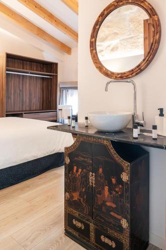 a bathroom with a sink and a bed with a mirror at Sa Pobla Rooms Ex Flor de Mandarina in Sa Pobla