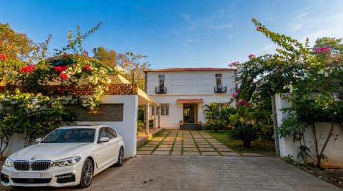 a white car parked in front of a house at De Majestic Grand Villa in Auroville