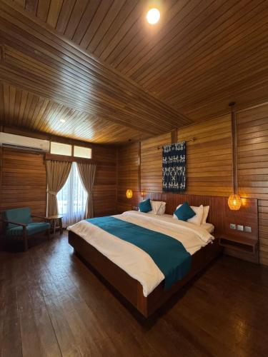 a bedroom with a large bed in a wooden room at Casa Kandara in Waingapu