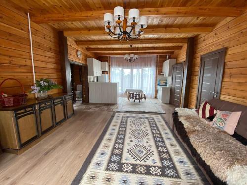 a living room with a couch and a chandelier at Нур Срубы Сары Ой in Chon-Sary-Oy