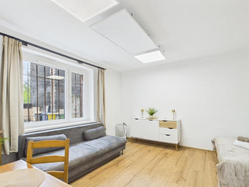 a living room with a couch and a window at Apartamenty Retro Loft in Chorzów