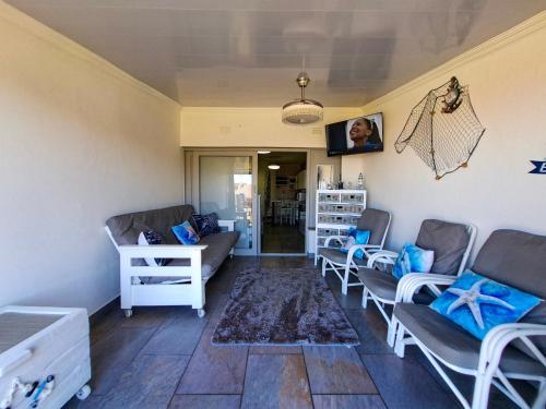 a living room with couches and blue pillows at Eden Dunes 75B in Shelly Beach
