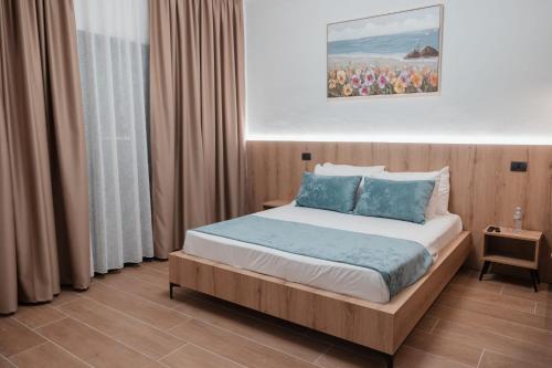 a bedroom with a large bed with blue pillows at Matteo Garden & Restaurant in Vlorë