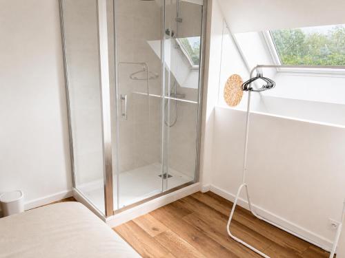 a shower with a glass door in a room at Petit Castel in Châteaubriant