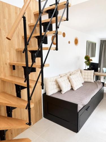 a bed in a room with a spiral staircase at Petit Castel in Châteaubriant