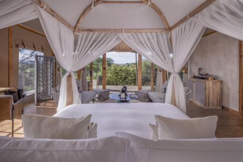 a room with white tables and chairs in a tent at JW Marriott Masai Mara Lodge in Masai Mara