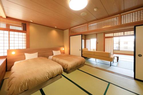 a bedroom with two beds in a room with windows at ゆるり奥日光withDOGS in Nikko