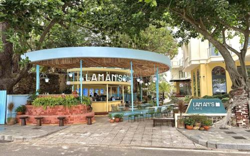 a restaurant with tables and benches in front of a building at Golden Rose Hotel in Con Dao