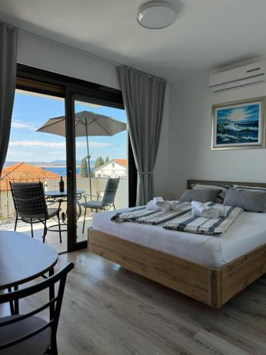a bedroom with a bed and a patio with a table at Vila Peričić in Dramalj