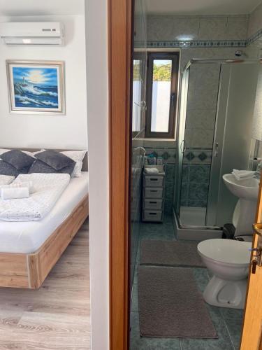 a bedroom with a bed and a bathroom with a shower at Vila Peričić in Dramalj