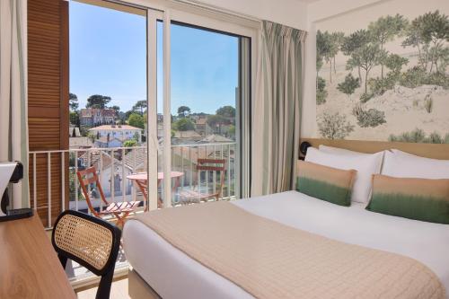 a bedroom with a bed and a balcony with a view at Best Western Arcachon Le Port in Arcachon