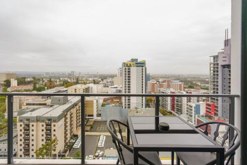 a balcony with a table and chairs in a city at Quest East Perth in Perth