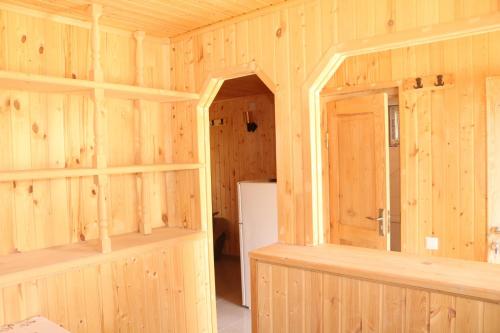an empty room with wooden walls and a refrigerator at Katie in Tianeti in Zhebota