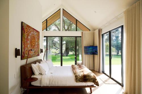 a bedroom with a bed and a large window at The Vale Penrose in Penrose