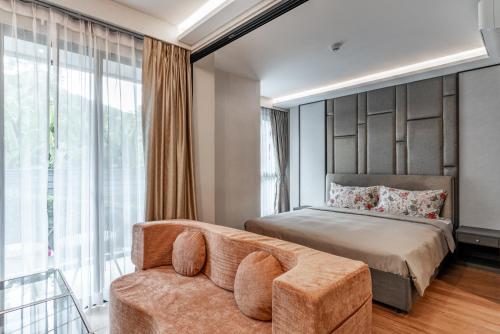 a bedroom with a bed and a couch at Panora Condo by Villacarte in Surin Beach