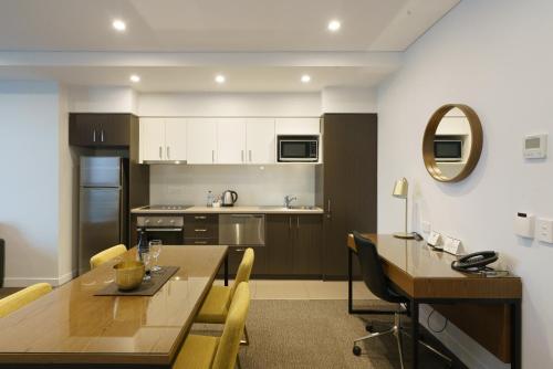 a kitchen and dining room with a table and chairs at Quest East Perth in Perth