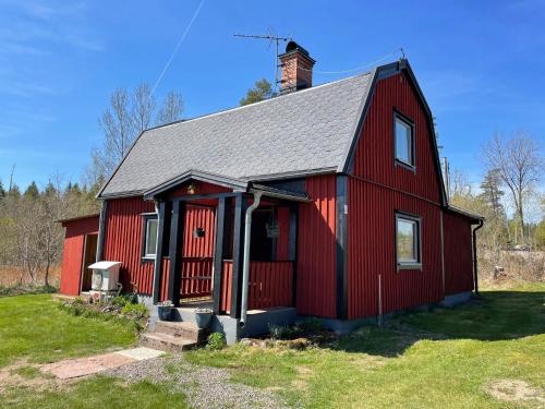 a red barn with a chimney on top of it at 5 person holiday home in ULRIKA in Rimforsa