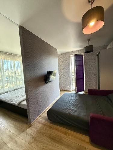 a bedroom with a bed and a tv on a wall at Apartment Versailles Park 1 in Irpin