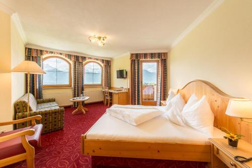 une chambre d'hôtel avec un lit et une chaise dans l'établissement Hotel Jägerhof, à Kolsassberg