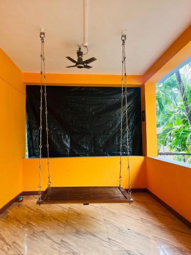 a swing in a room with yellow walls at Sukrut Villa, Alibag in Thāl