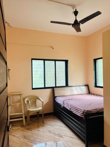 a bedroom with a bed and a chair in it at Sukrut Villa, Alibag in Thāl