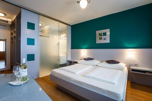 a bedroom with a bed and a green wall at Weingut Franz Schindler in Mörbisch am See