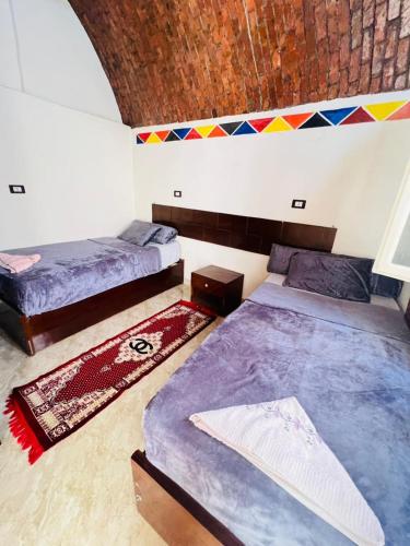 a bedroom with two beds and a ceiling at Dara guest House in Aswan
