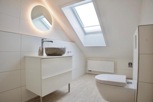 a bathroom with a toilet and a skylight at England 5 in Nordstrand