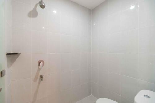 a bathroom with a shower and a toilet at RedDoorz @ Kisaran Kota in Kisaran