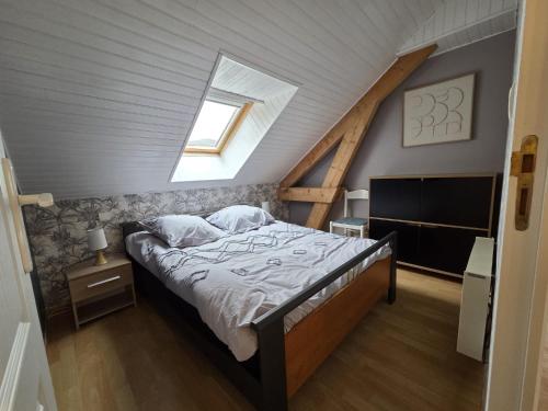a bedroom with a bed in a attic at au pont vieux in Chanac