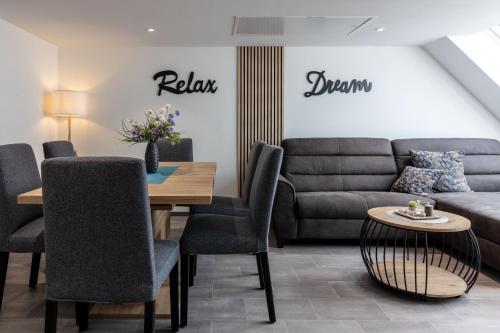a living room with a couch and a table at Asweiler Landliebe - klimatisierte Premiumfewo mit Balkon und Fernblick in Freisen