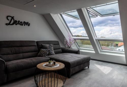 a living room with a couch and a table at Asweiler Landliebe - klimatisierte Premiumfewo mit Balkon und Fernblick in Freisen