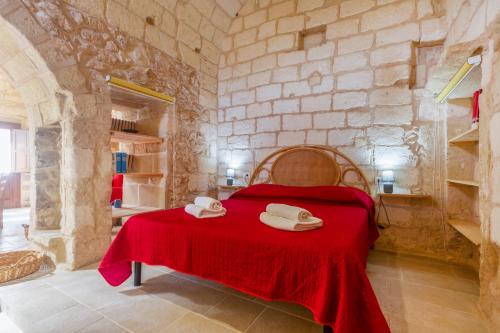 a bedroom with a red bed with towels on it at GuestHost - La Pizzica Apartment in Cannole