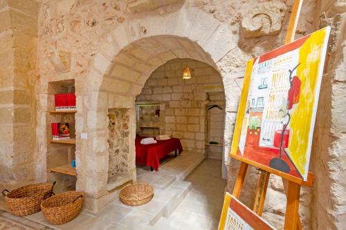 an archway with a painting in a room with a table at GuestHost - La Pizzica Apartment in Cannole