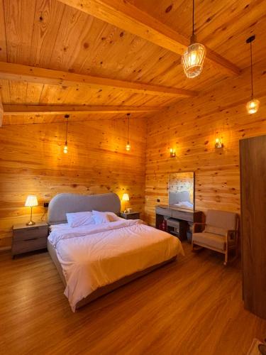 a bedroom with a bed and a desk in a room at كوخ الجنة in Abha